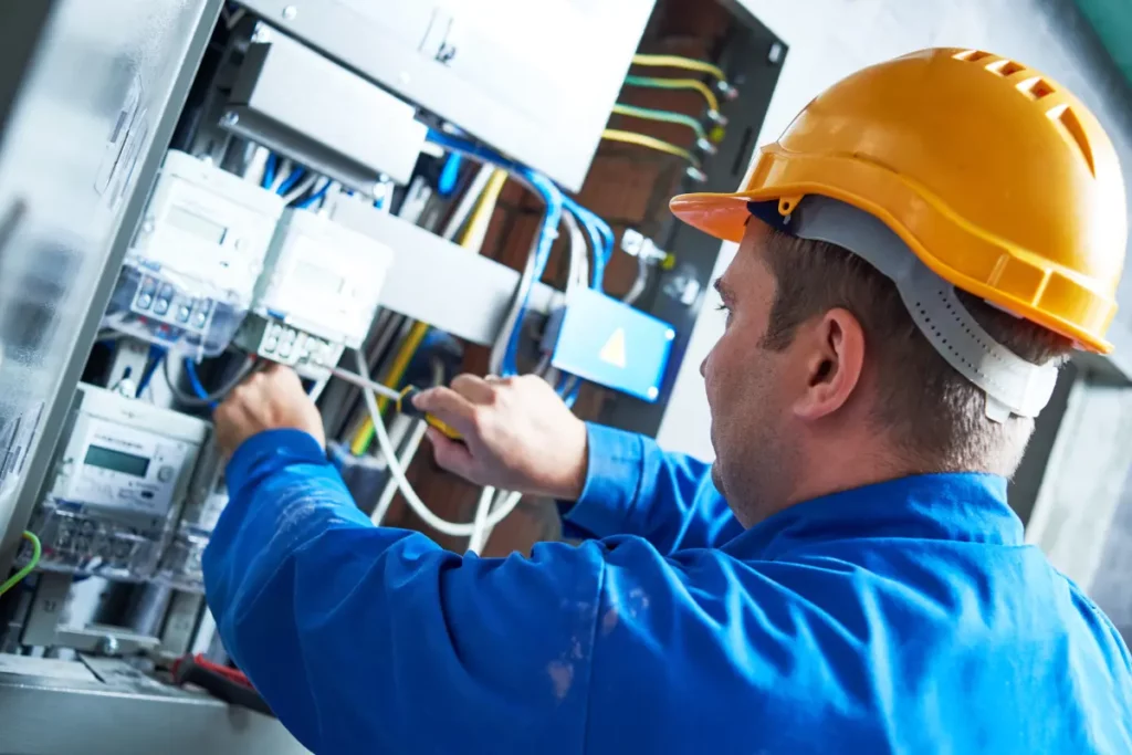 Persona realizando instalaciones eléctricas en una empresa